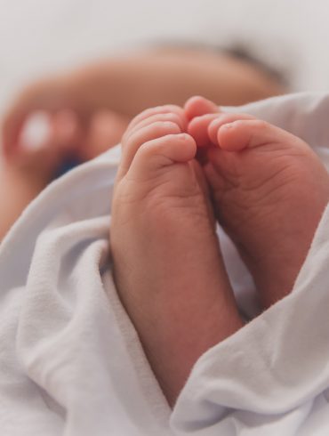 baby covered with white blanket