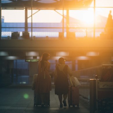 two women walking with luggage bags