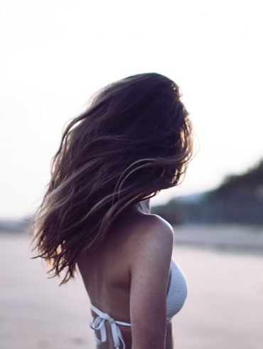 woman standing wearing white bra in selective focus photography