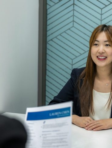 a woman sitting at a table with a piece of paper in front of her