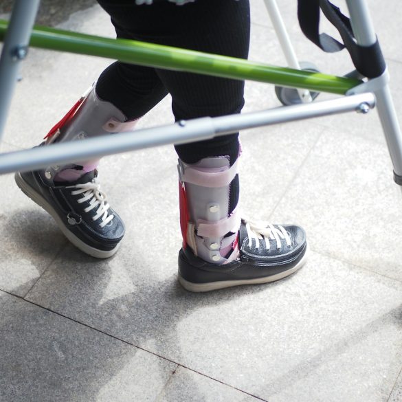 A person standing next to a green walker