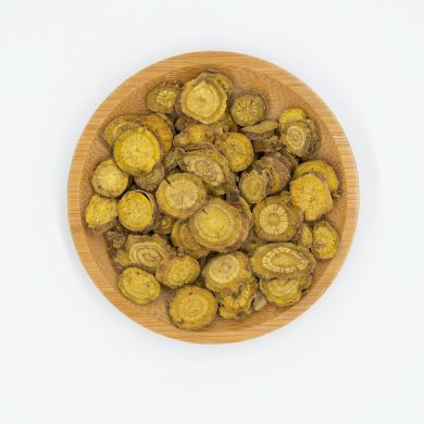 a wooden bowl filled with green vegetables on top of a white table