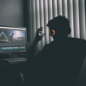 shallow focus photography of man listing to music in front of the computer