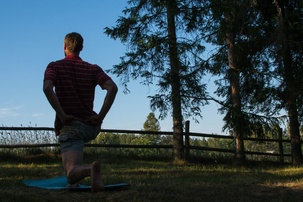 a man standing on a surfboard in the grass