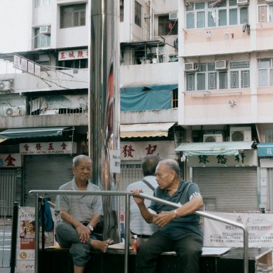 a couple of men sitting on top of a metal pole