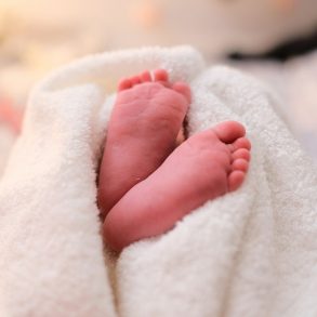 baby covered with white blanket